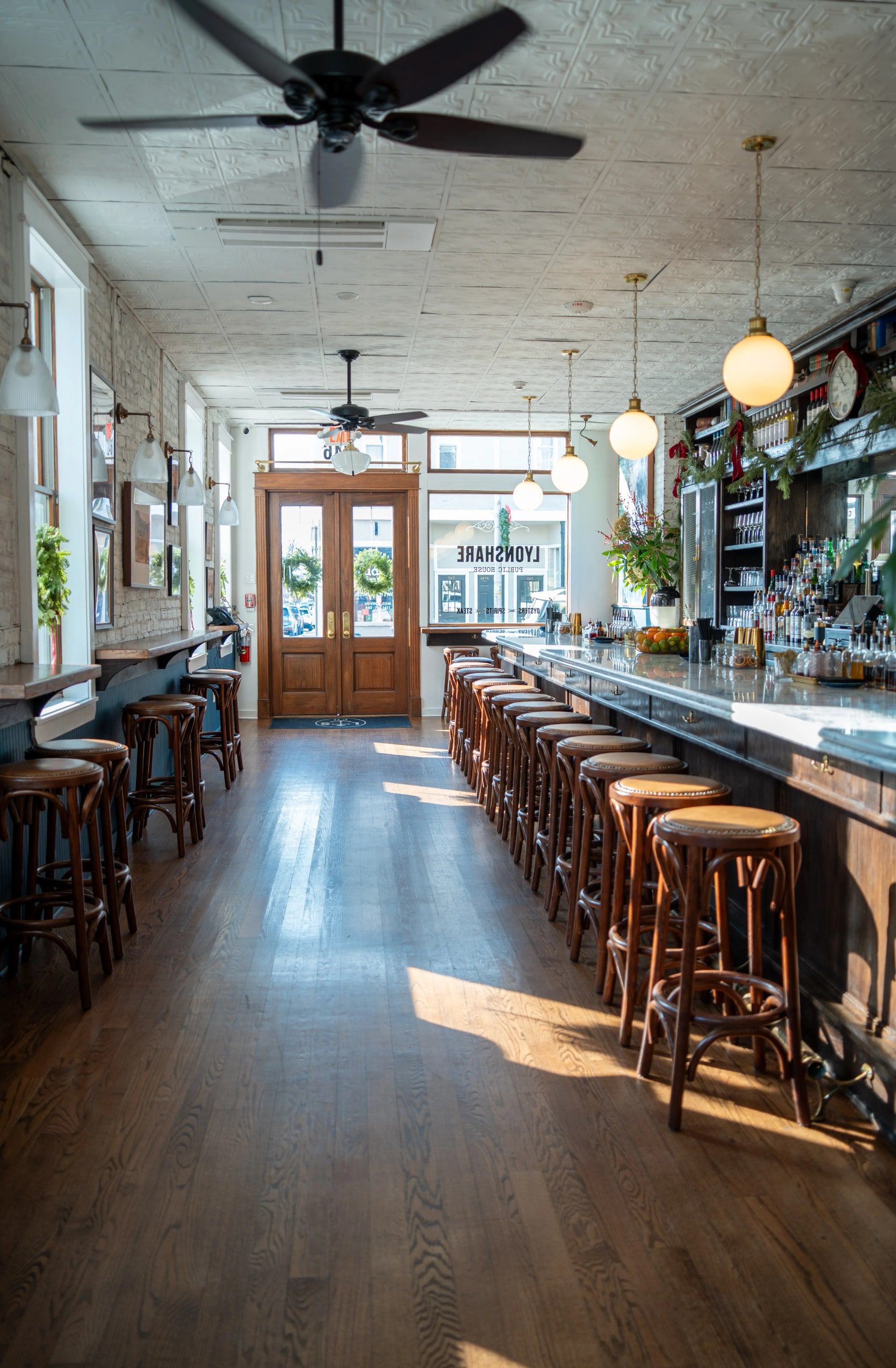 The long dining room at Lyonshare, with the bar on one side and the front doors at the far end.