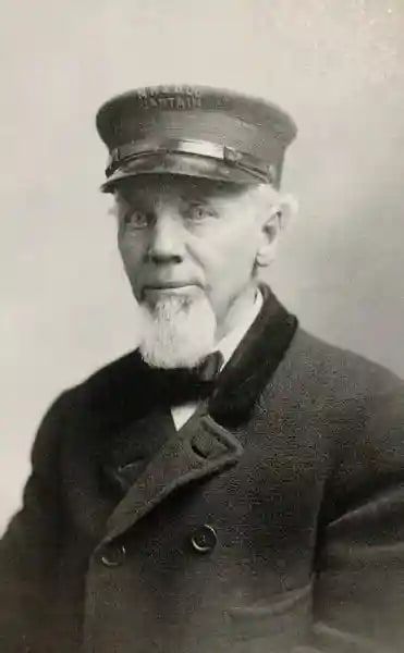 A historic portrait of Captain John Lyon in a captain’s cap.